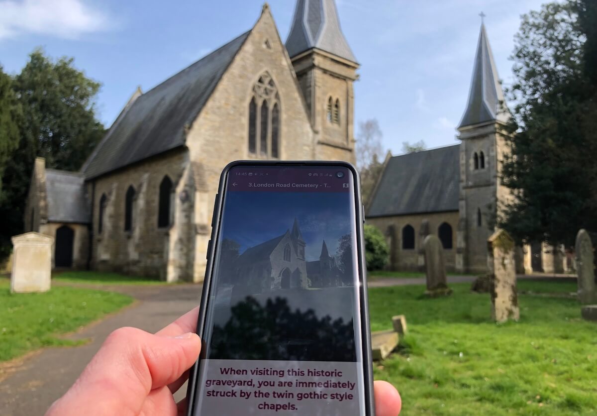 london road cemetery - church with phone held up in front showing image of church and information about the area